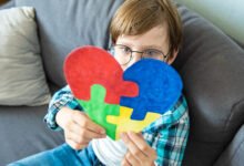 Criança com desenho de peças de puzzle coloridas representando o autismo na Paraíba.