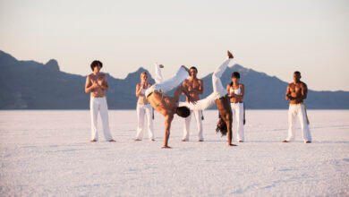 capoeira origem sendo demonstrada em uma roda com movimentos tradicionais ao ar livre