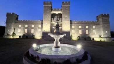 Fachada iluminada do Castelo da Torre na Paraíba com fonte central ao anoitecer