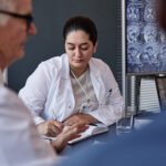 médicos em reunião analisando casos clínicos, representando discussão sobre formação e avaliação na OAB da Medicina